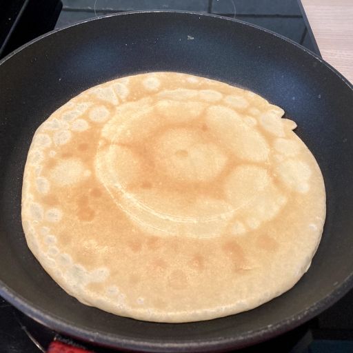 Cooked side of the pancake in the pan