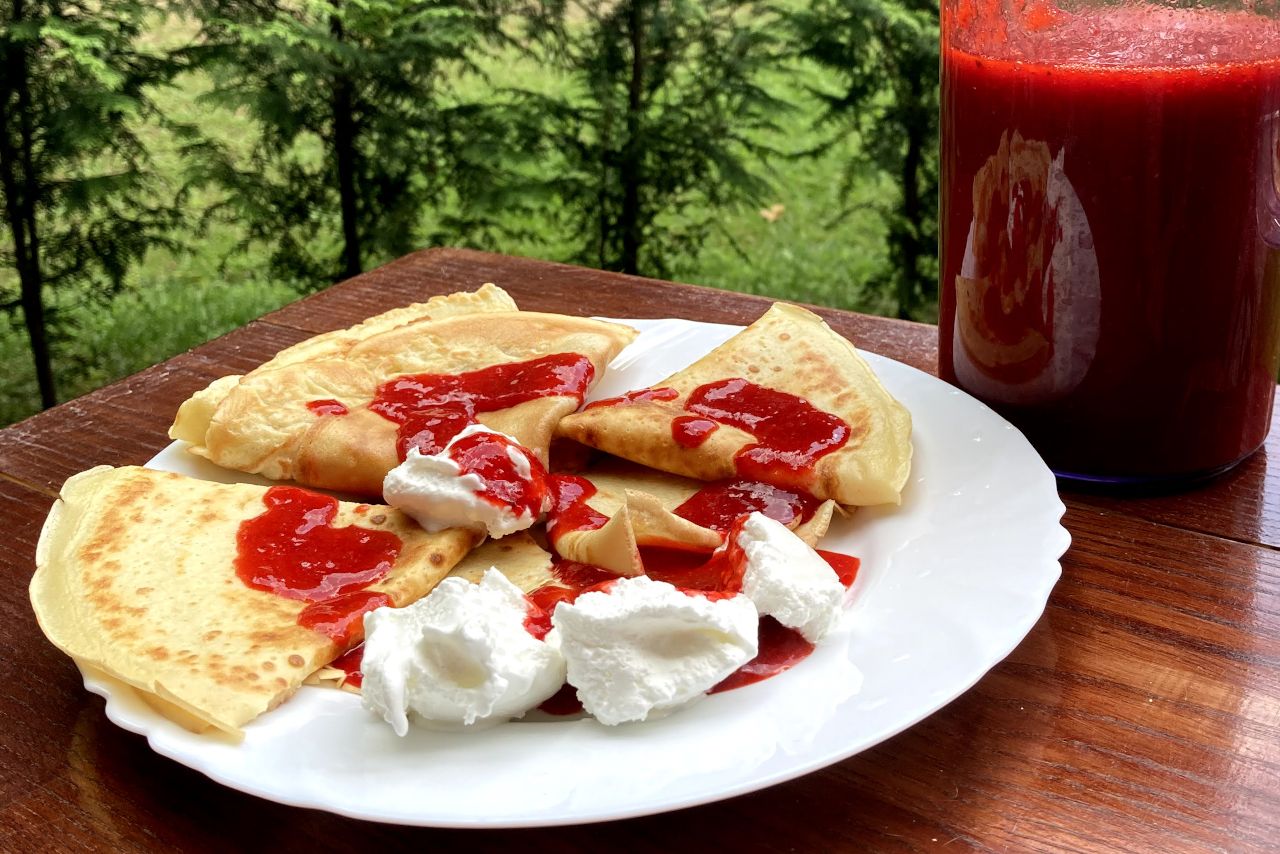 Prepared pancakes with ice cream and mashed strawberries